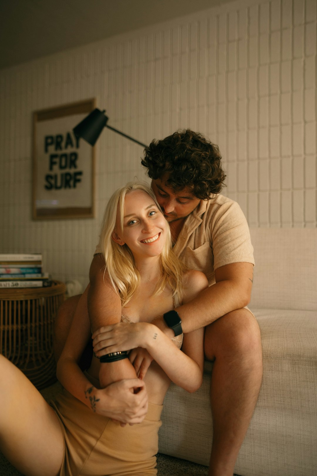 Una pareja sentada muy junta en un sofá de casa